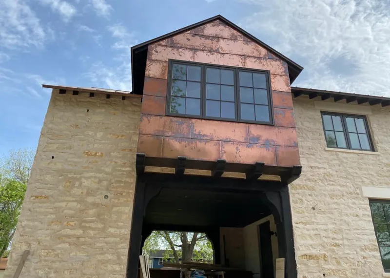 Copper metal panel facade on a stone building for Metal Roof Coating in Center Line
