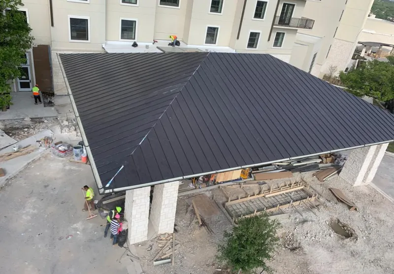 Metal roofing installation team working on a commercial building in Center Line